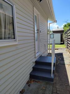 una casa con escaleras que conducen a una puerta en Small 2-bedroom flat at Rangiatea Road, Epsom, Auckland, en Auckland
