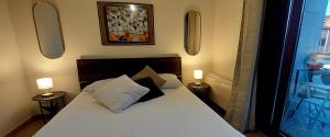 una camera da letto con un letto bianco con due lampade di Trigoria Suite a Selcetta