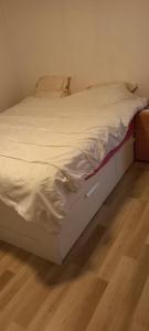 un lit défait dans une chambre avec un plancher en bois dans l'établissement Maison calme, à Payrin-Augmontel