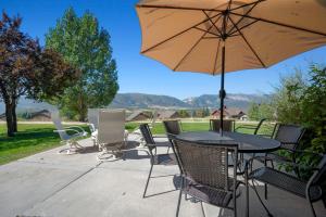 a table and chairs with an umbrella on a patio at Powder Mtn Trapper Lodge TR1 Ski Retreat Game Rm in Eden