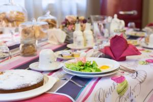 a table with plates of food and a salad on it at B&B Annabel in Milan
