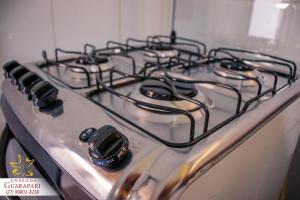 a stove top with a bunch of burners on it at CONFORTO IMBATIVEL - 25 metros do MAR - 2 Quartos com AR CONDICIONADOS SPLIT, Air Fryer, WI-FI, Disney Plus, Star Plus, HBO Max, Cadeiras de Praia e Caixa Térmica - 8 pessoas com Muito Conforto - Melhor Localização! in Guarapari