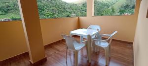 a table and chairs in a room with a large window at Pousada Alejandro in Cunha