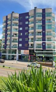 een groot appartementencomplex voor een straat bij Apto Lírio da Paz- 3 Quartos com sacadas,espaçoso e de frente para avenida principal! in Piratuba