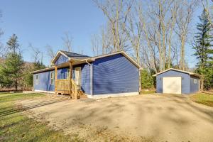 a blue house with a garage on a dirt road at Golf, Hike and Boat Home with Fire Pit in Friendship in Friendship