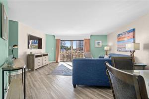 a living room with a blue couch and a table at Ocean View Ground Floor Pool and Hot Tub in Myrtle Beach