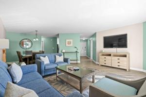 a living room with blue furniture and a flat screen tv at Ocean View Ground Floor Pool and Hot Tub in Myrtle Beach +46 photos