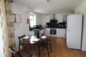 a kitchen with a table and chairs and a white refrigerator at Hady House in Chesterfield