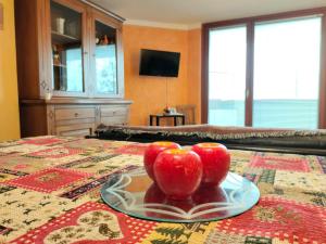 two apples on a plate on a bed at Casa Elvezia in Breuil-Cervinia