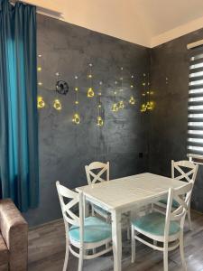a dining room with a white table and chairs at Shahdag Mountain House in Qusar