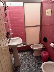 a pink bathroom with a sink and a toilet at Nuevo complejo Clarita in Villa Carlos Paz +33 photos