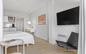 Un dormitorio con una cama, una mesa y un televisor. en Cozy Apartment In Gudhjem, en Gudhjem