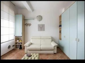 a living room with a white couch and a chair at Apartment Monza park-autodrome-hospital-villa reale in Monza