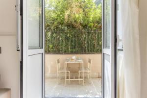 an open door to a patio with a table and chairs at Aragona House in Palermo