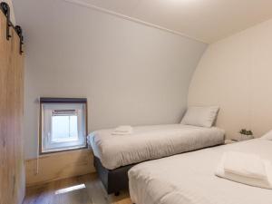 two beds in a small room with a window at Thatched Home in Overijssel in De Bult