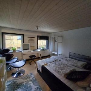 a bedroom with a bed and a desk with a computer at Villa Sommersted Andersen in Sommersted