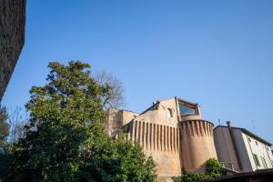 a brick building with a tree in front of it at MENTORE MAISON PRESTiGE in Noceto