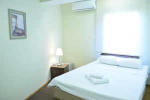 a bedroom with a white bed with a window at Urban Vibe Apartments 2 in Skopje