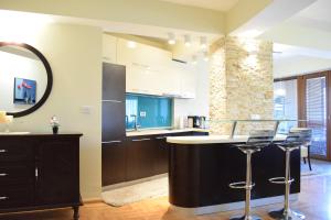 a kitchen with a bar with stools and a mirror at Urban Vibe Apartments 2 in Skopje