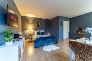 une chambre avec des murs bleus et un lit dans une chambre dans l'établissement L'Azur - Parking privé - Hypercentre - Wifi, à Marcq-en-Barœul