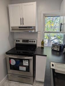 une cuisine avec une cuisinière et un comptoir dans l'établissement Luxury Studio located in downtown windsor for short term stay, à Windsor