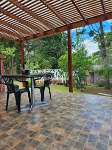a patio with a table and chairs under a wooden pergola at valeriadelmar in Valeria del Mar