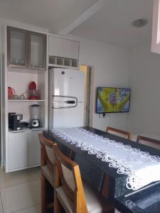 a kitchen with a table with chairs and a refrigerator at CASA DA NATY in Morro de São Paulo