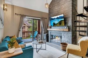 a living room with a blue couch and a fireplace at Renovated Ski In Ski Out Condo at Holiday Valley in Ellicottville