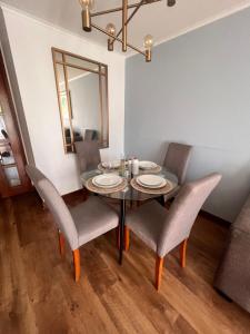 Una mesa de comedor con sillas y un espejo. en Departamento Nuevo en Ñuñoa full equipado, en Santiago 6 fotos más