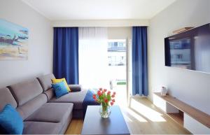 a living room with a couch and a vase of flowers on a table at Adrian Apartament in Herăstrău