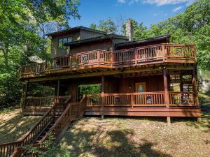 a large house with a wrap around deck at Spacious Chalet Hot Tub Sauna Holiday Valley in Ellicottville