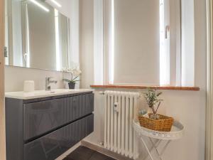 a bathroom with a sink and a mirror and a radiator at Appartamento vicino Università Parcheggio Privato in Ferrara