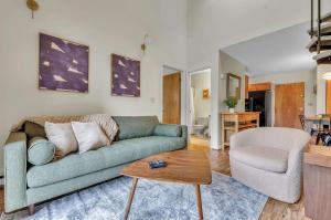 a living room with a green couch and a chair at Updated Ski In Ski Out Condo Holiday Valley in Ellicottville