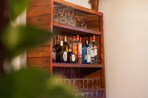 a wooden cabinet with bottles and glasses on it at La Puesta del Sol B&B in Carrillo