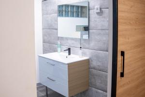 łazienka z białą umywalką i lustrem w obiekcie "City House" - Maison de ville en hypercentre - 2mn gare - BY PRIMO CONClERGERIE w mieście Mâcon