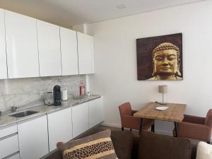 eine Küche mit einem Tisch und einer Kopfstatue in der Unterkunft AnaSol in Esposende