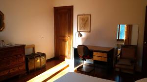 1 dormitorio con escritorio, silla y escritorio en Villa dei Pini en Villorba