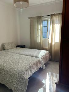 a white bedroom with a bed and a window at Casa La Alpispa in Frontera