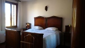 a bed with a wooden headboard in a bedroom at Villa dei Pini in Villorba