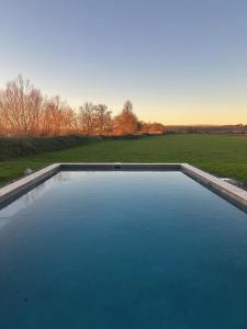 a large pool of water with a field in the background at Chateau de la Vieille Chapelle in Lugon et l’Ile du Carney