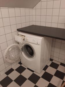 a washing machine in a bathroom with a counter at Krokbråten Gård vindsvåning in Åkers Styckebruk