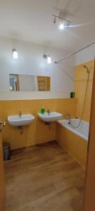 bagno con 2 lavandini, vasca e specchio di Skyline View Apartment - 15th Floor Bliss a Bratislava