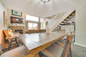 une salle à manger avec une table en bois et des escaliers dans l'établissement 1 Mi to Nubs Nob Ski Resort Harbor Springs Condo, à Harbor Springs