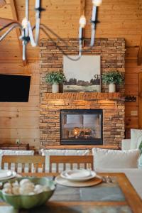 a living room with a fireplace and a table with chairs at Pinewood Chalet in Smithville