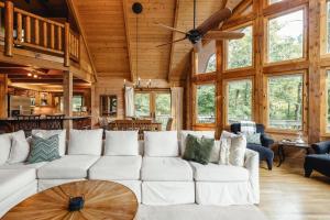 a living room with a white couch and a ceiling fan at Pinewood Chalet in Smithville +53 photos