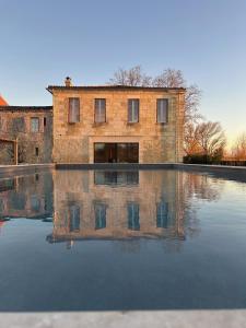 a brick building is reflected in a pool of water at Chateau de la Vieille Chapelle in Lugon et l’Ile du Carney