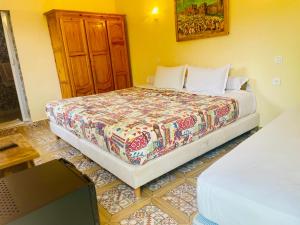 a bedroom with a bed and a wooden cabinet at Villa Baddi Marrakech in Marrakesh