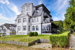 Ferienwohnung Bernstein in der Villa Rex Sellin في اوستيباد سيلين: منزل أبيض مهيب بساحة كبيرة