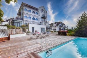 Ferienwohnung Bernstein in der Villa Rex Sellin في اوستيباد سيلين: منزل وسطح خشبي ومسبح