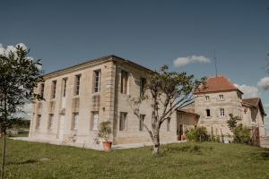 an old building with a tree in front of it at Chateau de la Vieille Chapelle in Lugon et l’Ile du Carney